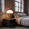 Maravelle industrial glass and metal table lamp glowing on a loft bedroom nightstand