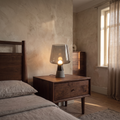 Noctura vintage tinted glass and stone table lamp glowing on a bedside table