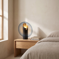 Amberlyn modern glass table lamp glowing warm on an oak bedroom nightstand
