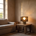 Elmira rustic ribbed smoked glass table lamp with brass base lit on an oak side table
