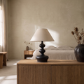 Xanthe boho fabric and wood table lamp glowing softly in a Japandi style bedroom