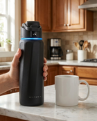 Smart Water Bottle Scale Reference - hand holding bottle next to regular cup