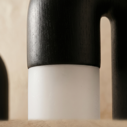 Close-up of Delacroix table lamp matte black wood tube meeting the acrylic diffuser