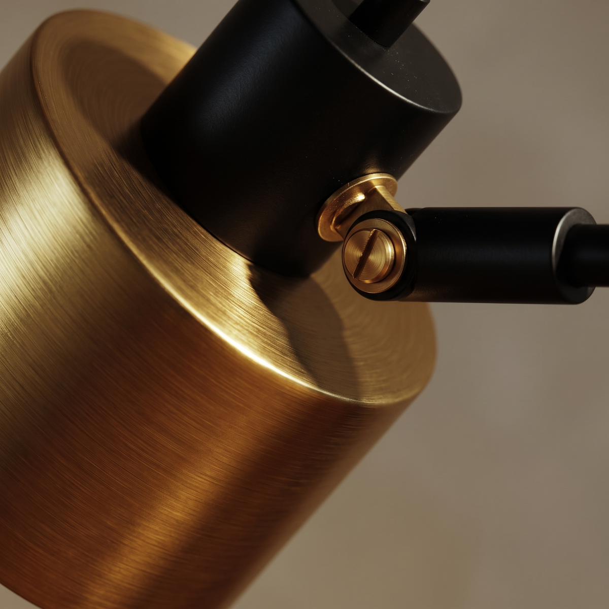 Macro detail of the Sablette lamp's brushed brass cylinder head and pivot joint