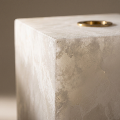 Macro detail of the Duvessa lamp's honed alabaster corner, natural veining and brass ring