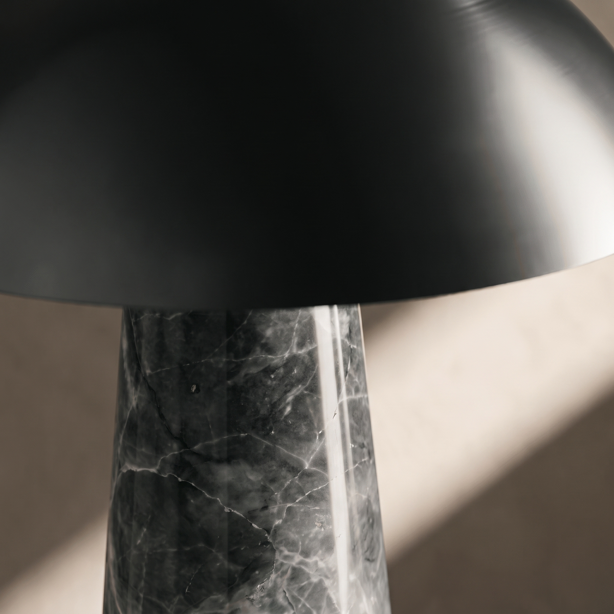 Rosalind table lamp detail, black steel dome rim and grey marble veining macro