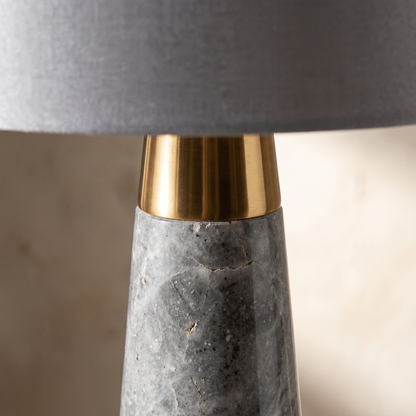 Pravelle table lamp detail, brass collar and grey stone base texture close-up