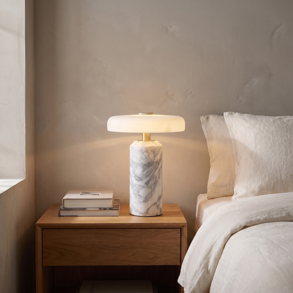 Ophira contemporary glass and marble LED table lamp glowing warm on a bedroom nightstand