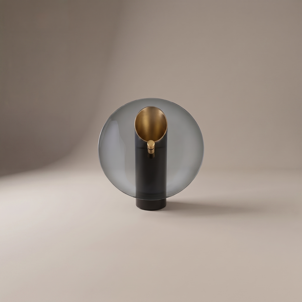 Amberlyn modern table lamp with smoke glass disc and gold-lined black cylinder on a neutral studio backdrop