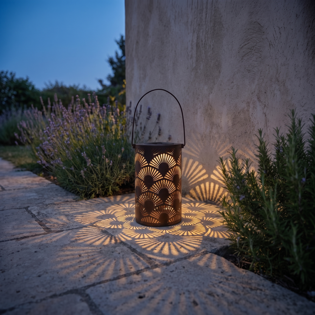 Lucerna traditional metal garden lantern glowing at dusk on a stone garden path