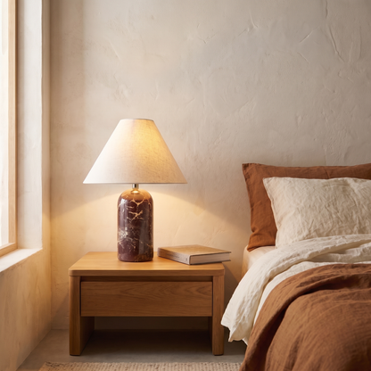 Vionelle contemporary red marble table lamp with cream fabric shade lit on a bedroom nightstand