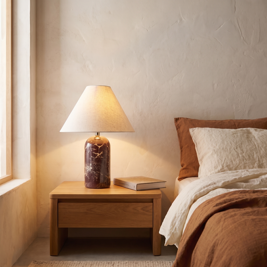 Vionelle contemporary red marble table lamp with cream fabric shade lit on a bedroom nightstand