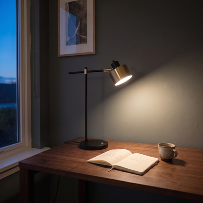 Sablette reading lamp casting a warm light pool over a home office desk at dusk