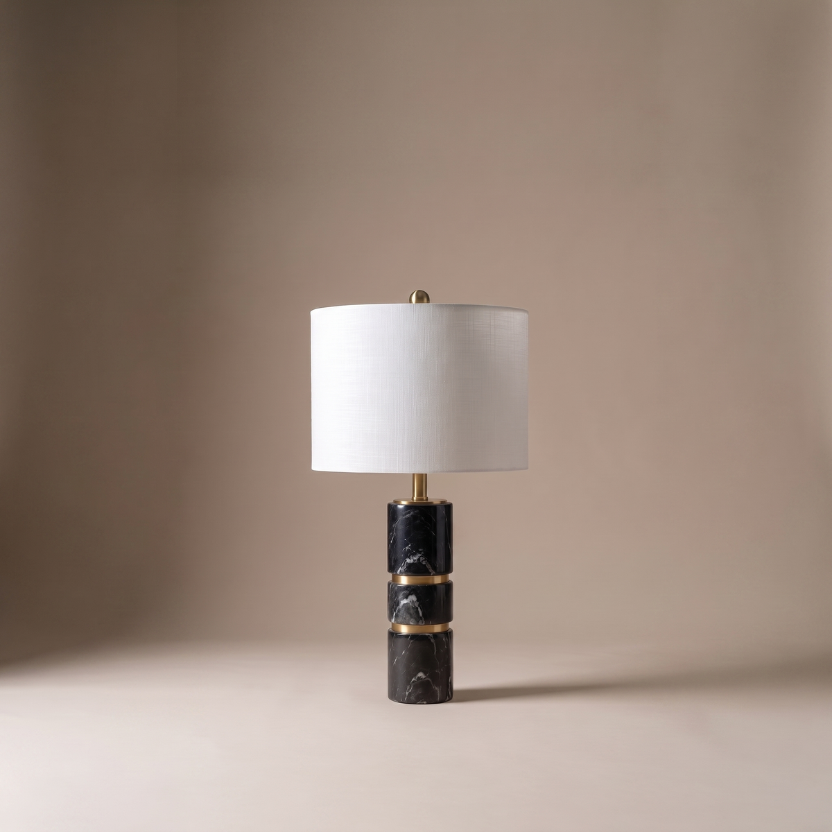 Cavour stacked black marble column table lamp with brass rings and white fabric drum shade, studio shot