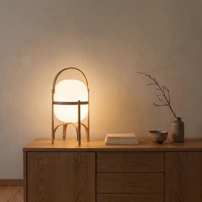 Galante glass and wood table lamp lit at dusk on an oak sideboard in a Japandi living room