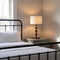 Montrave classic table lamp with turned walnut bobbin base glowing on an elegant bedroom nightstand