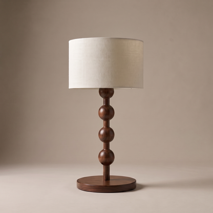 Montrave traditional walnut wood table lamp with cream drum shade on neutral studio backdrop