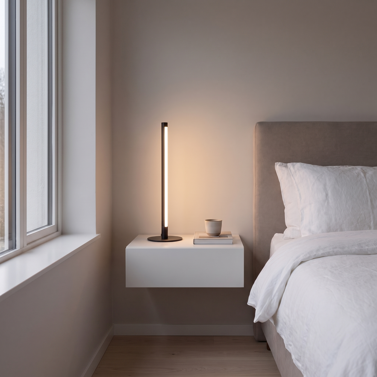 Nervesa modern black LED line table lamp glowing warm on a floating nightstand in a contemporary bedroom