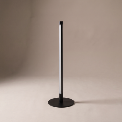 Nervesa minimalist metal table lamp with vertical LED diffuser and round disc base on studio backdrop