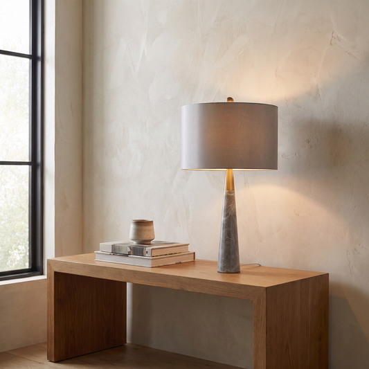 Pravelle modern table lamp with grey stone base and fabric drum shade glowing warm on a living room console