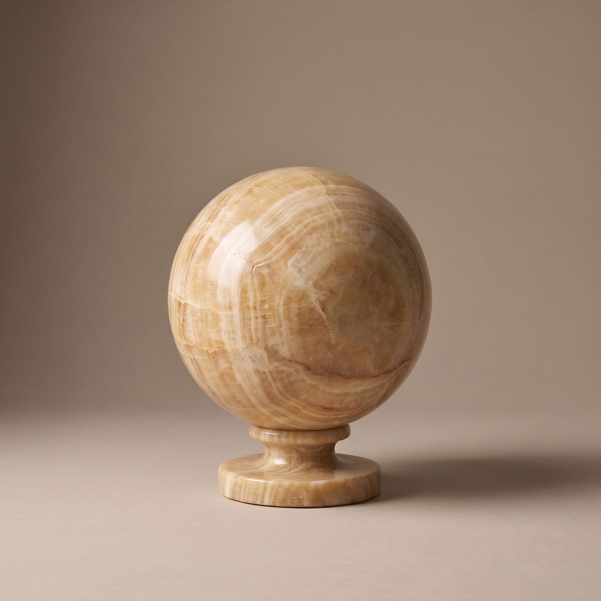 Quillon marble table lamp, honey onyx sphere on pedestal base, studio product shot