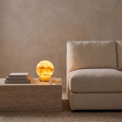 Quillon onyx marble LED table lamp glowing at dusk on a living room side table