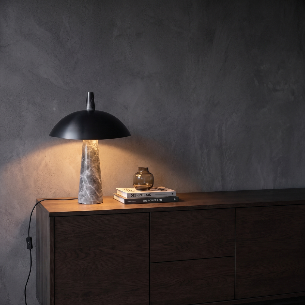 Rosalind black dome marble table lamp glowing on a living room sideboard at evening