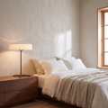 Tavernelle modern LED table lamp with white drum shade and black tripod base on a bedroom dresser