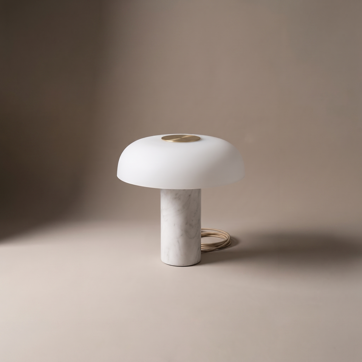 Umbriel modern table lamp with white dome shade and brass disc on stone base, studio product shot