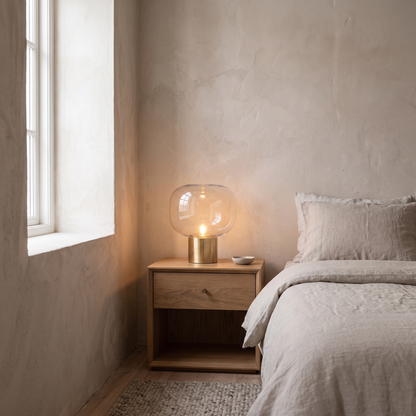 Vercelli modern aluminum and glass table lamp glowing warm on a bedroom nightstand