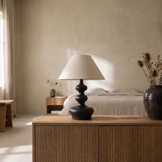 Xanthe boho fabric and wood table lamp glowing softly in a Japandi style bedroom