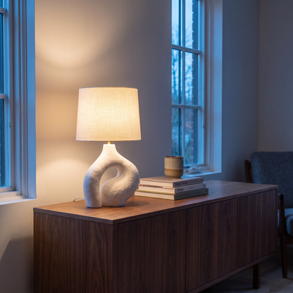 Ysoline modern retro table lamp lit warm on a walnut sideboard at dusk