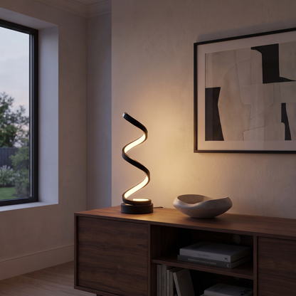 Cordelia slim aluminum LED table lamp lit on a walnut living room console at dusk