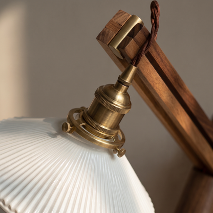 Close-up of brass socket, walnut arm and striped milk white glass shade on the Nordic retractable wall sconce