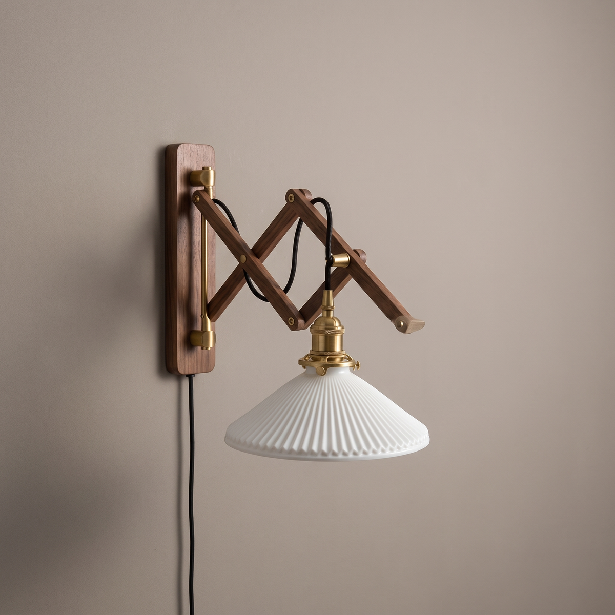 Nordic walnut retractable scissor-arm wall sconce with white ribbed glass shade and brass fittings on a plaster wall, lamp off