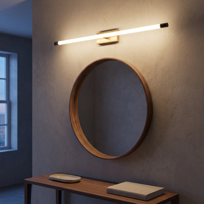 Minimalist tube LED vanity wall sconce lit above a round mirror and walnut console at dusk