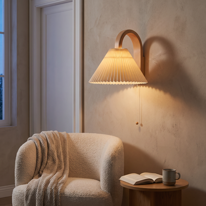 Wood pleated semi-circle wall sconce lit above a boucle armchair in a warm modern living room reading corner