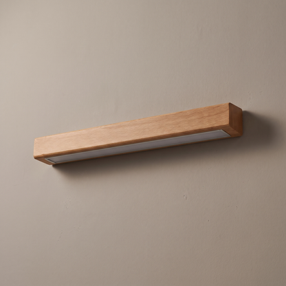 Brown solid wood linear LED wall light bar mounted on a greige plaster wall, lamp off