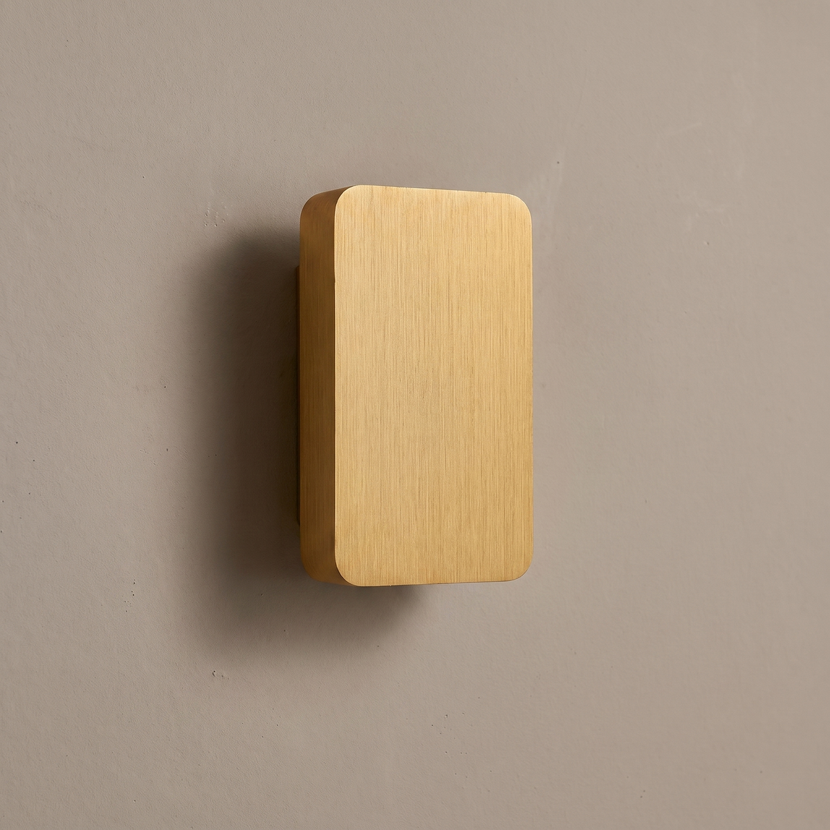 Brushed gold aluminum rectangular flat panel 2-light LED wall sconce mounted on a warm greige plaster wall, lamp off