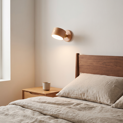Wooden USB rechargeable magnetic LED night light wall sconce in beech glowing warm beside a walnut headboard in a bedroom