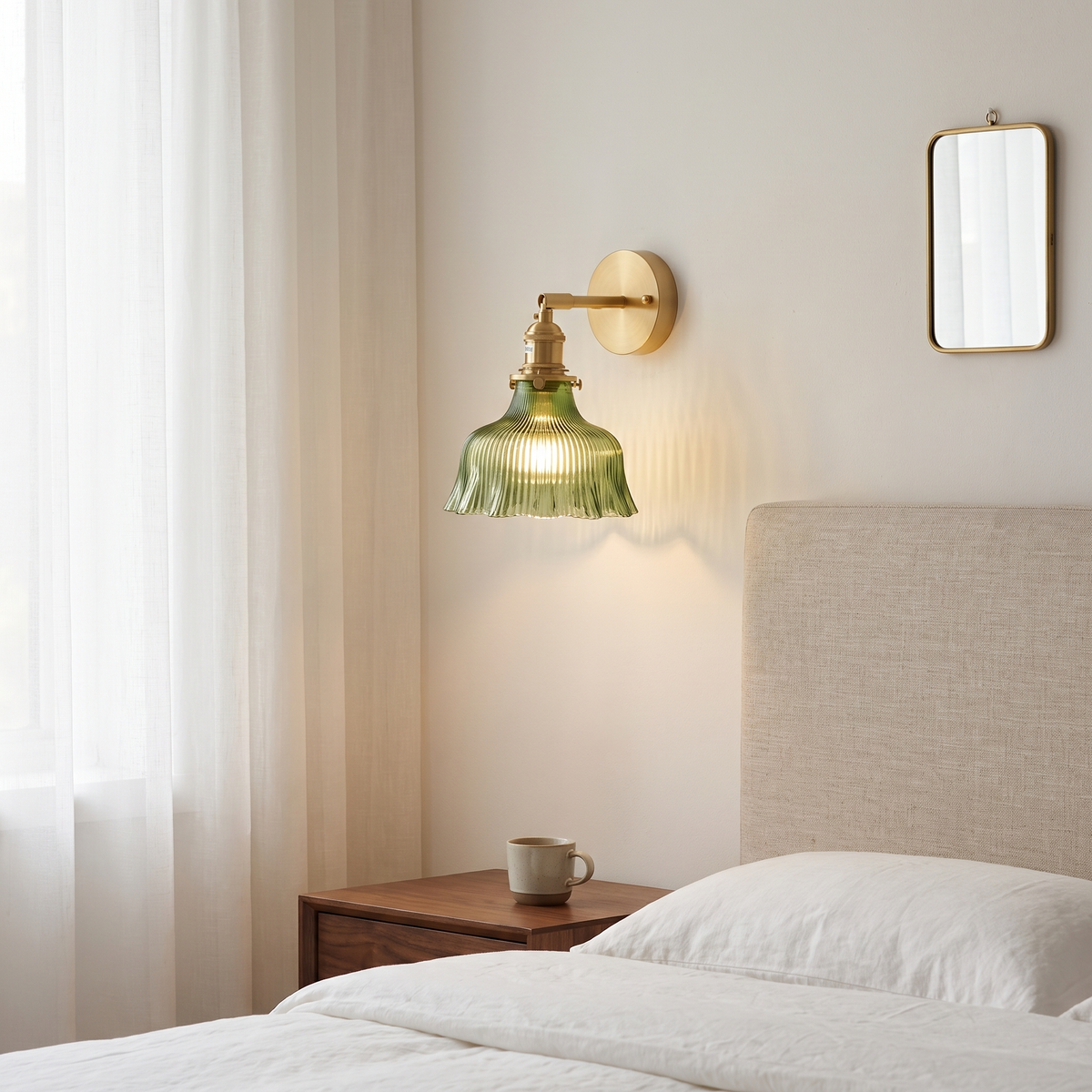 Nordic brass flower wall sconce with ribbed green glass shade glowing warm beside a linen headboard