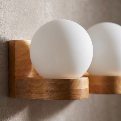 Close-up of the rubberwood grain and opal glass globe on the Nordic wooden wall sconce