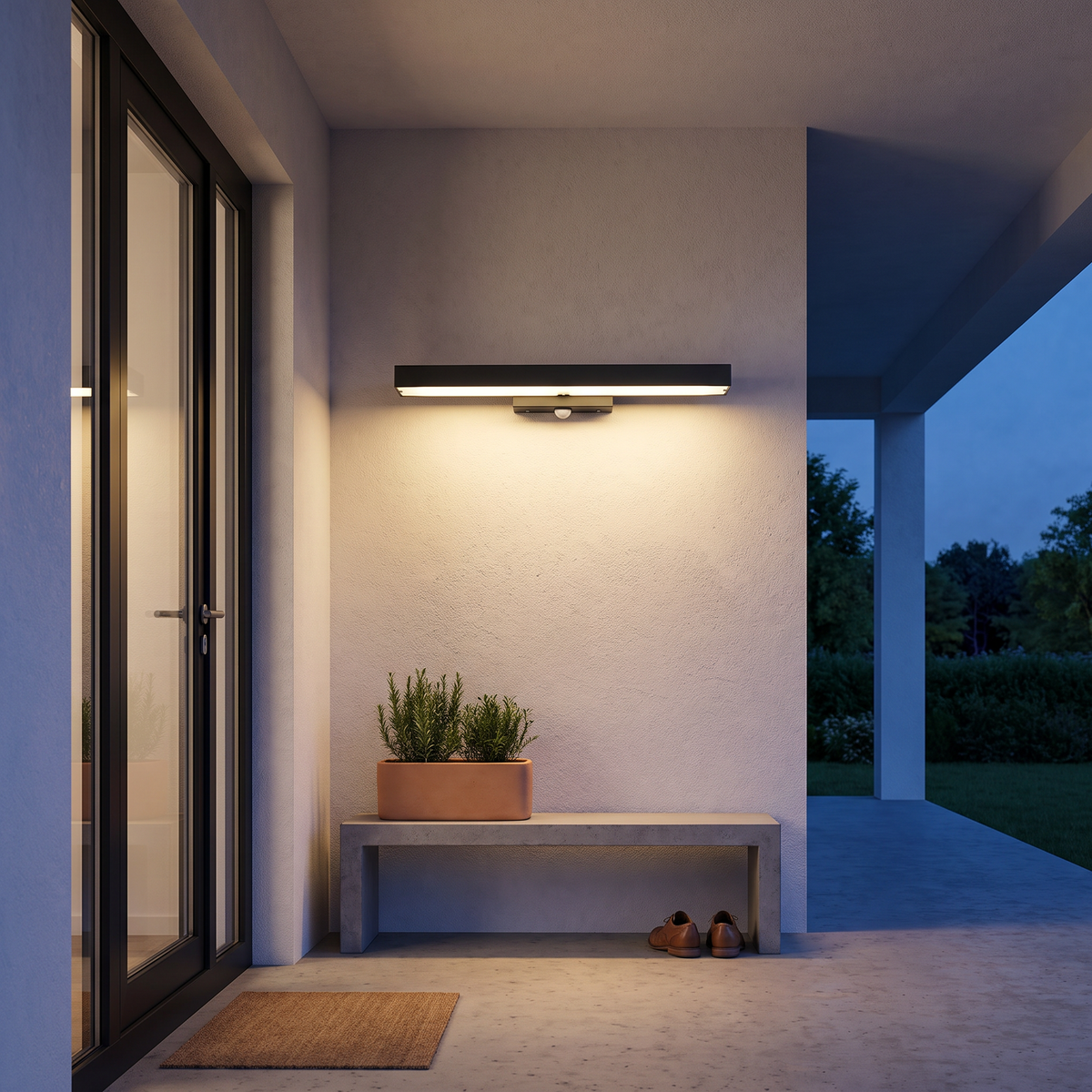 Rectangular black LED outdoor wall sconce lighting a modern covered entry porch at evening beside a black-framed door