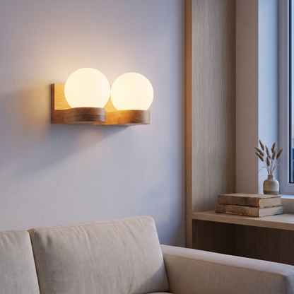 Rubberwood 2-light glass globe wall sconce lit at dusk above a linen sofa in a Nordic living room