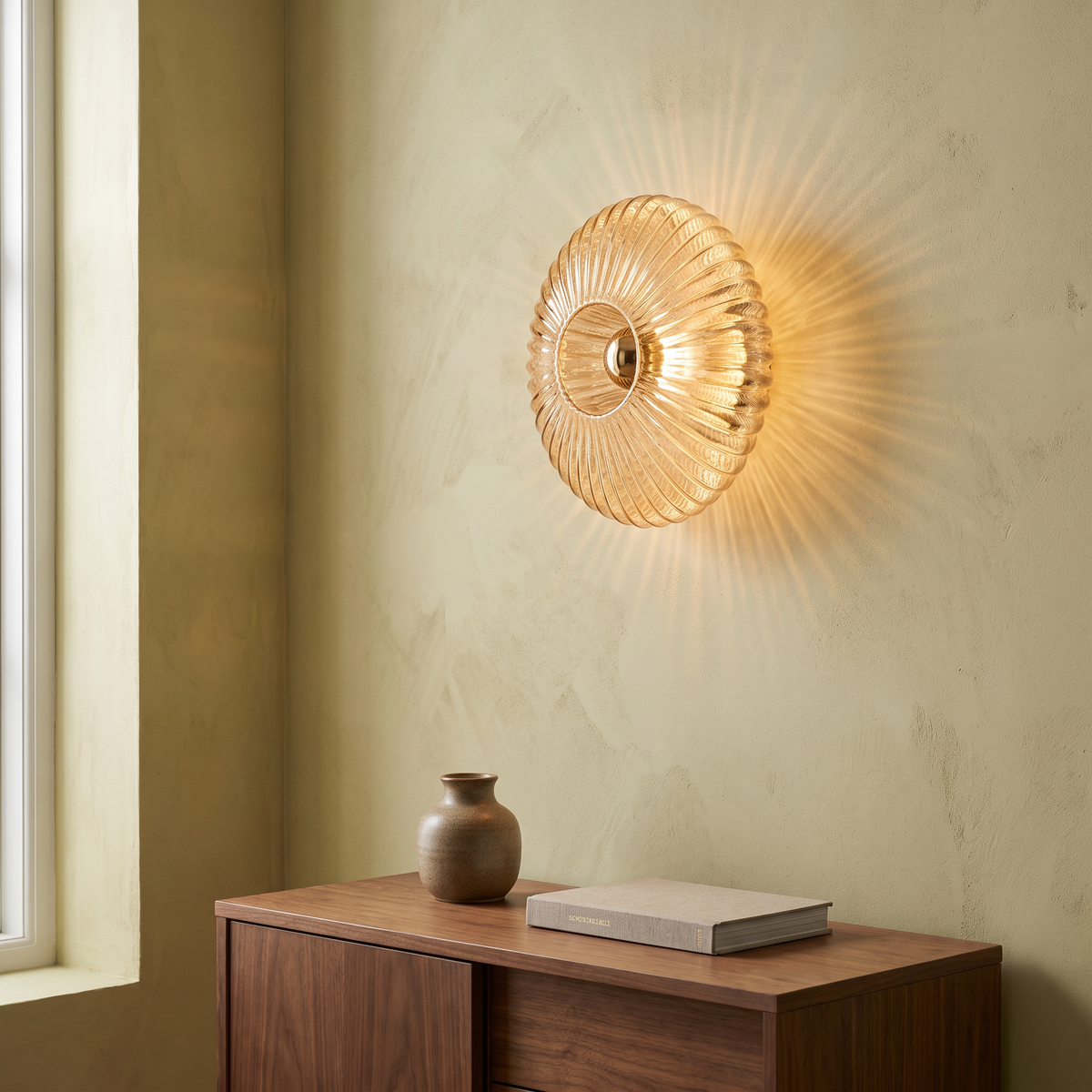 Nordic vintage cognac striped glass round disc wall sconce with brass fitting glowing warm above a walnut sideboard in a living room