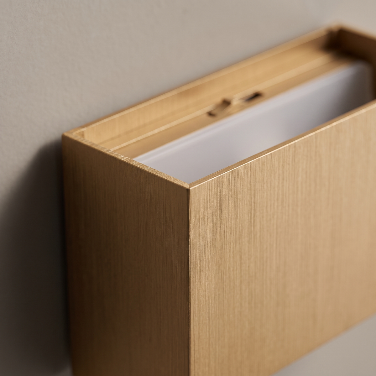 Close-up of the brushed gold aluminum corner and adjustable beam top slot of the minimalist square flat LED wall sconce