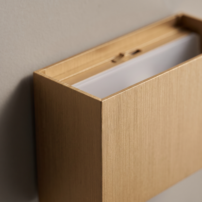 Close-up of the brushed gold aluminum corner and adjustable beam top slot of the minimalist square flat LED wall sconce