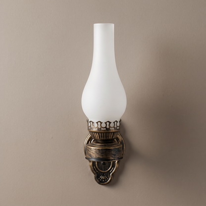 Retro kerosene 1-light antique bronze wall sconce with frosted glass chimney shade mounted on a plain greige wall, light off
