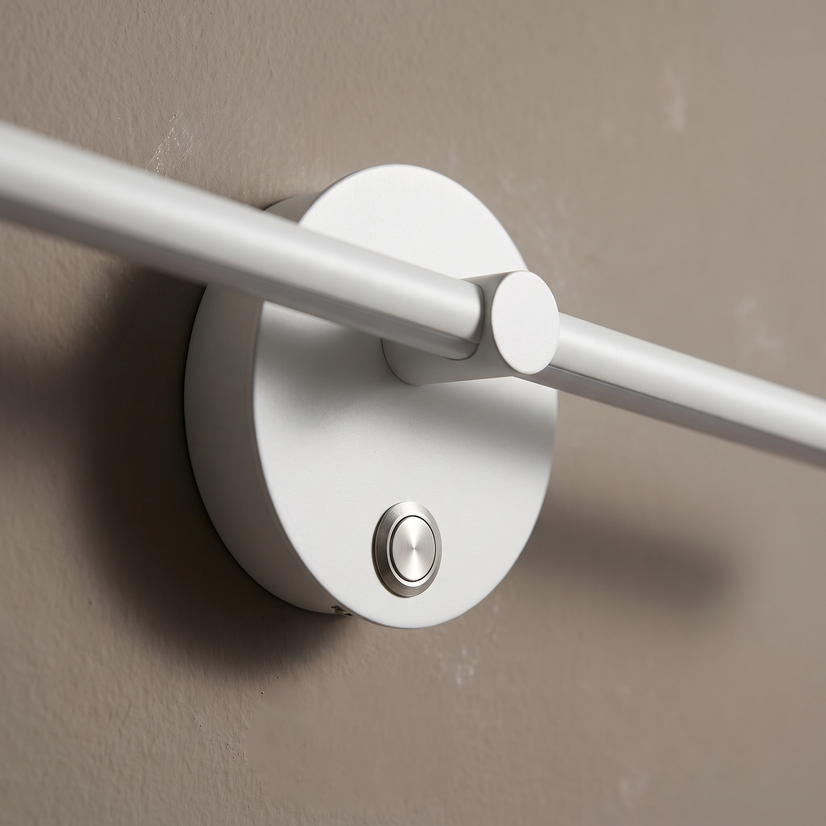Close-up of the white aluminum bar wall sconce round disc backplate and push switch, matte finish detail