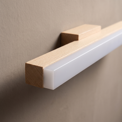 Close-up of the pale wood grain, acrylic diffuser edge and wooden mounting block of the strip vanity light